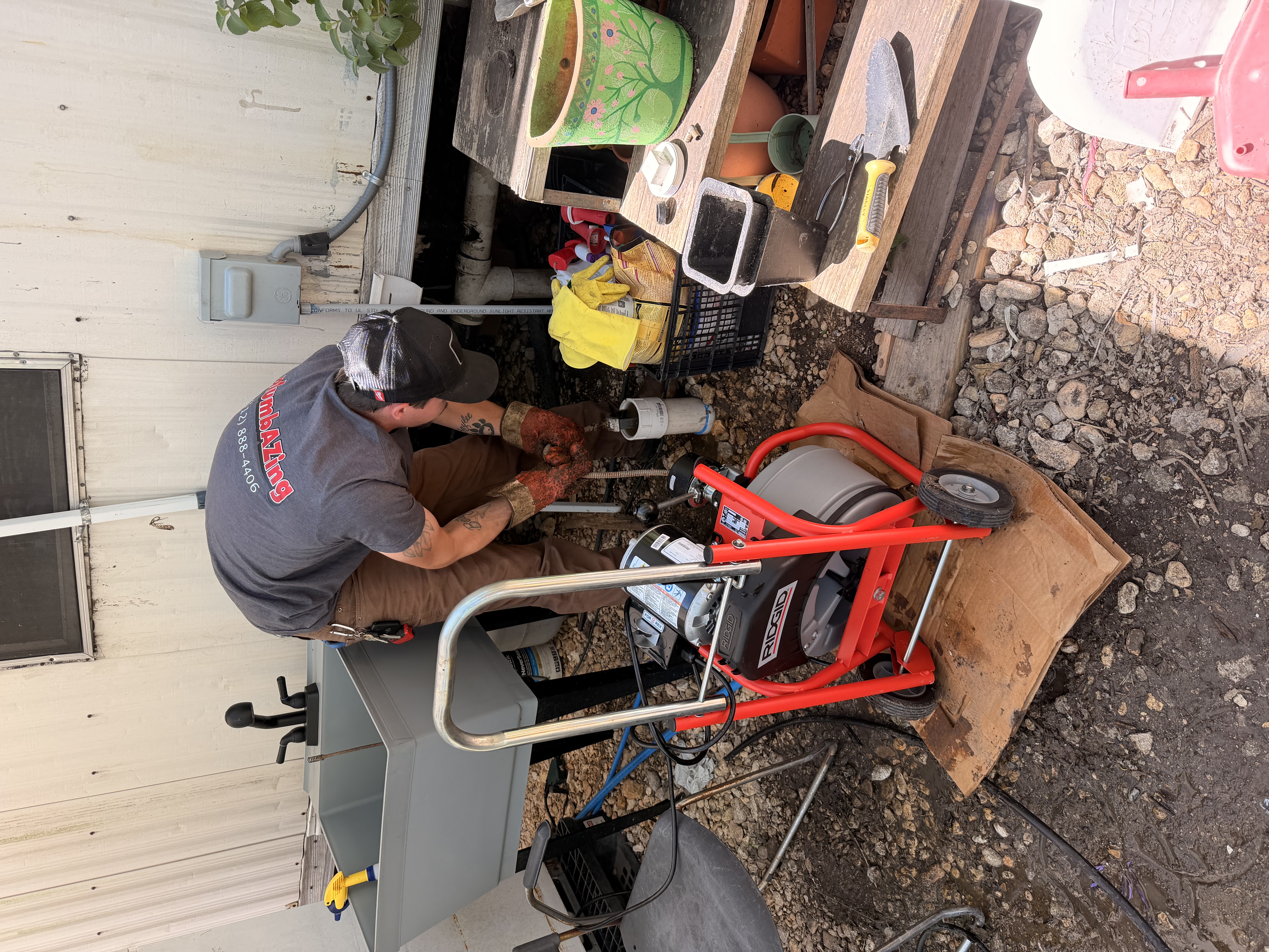 Alan clearing a main sewer line through a front yard cleanout.